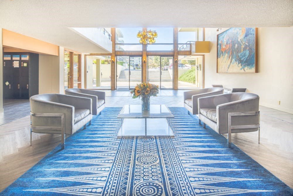 the lobby of a hotel with chairs and a table
