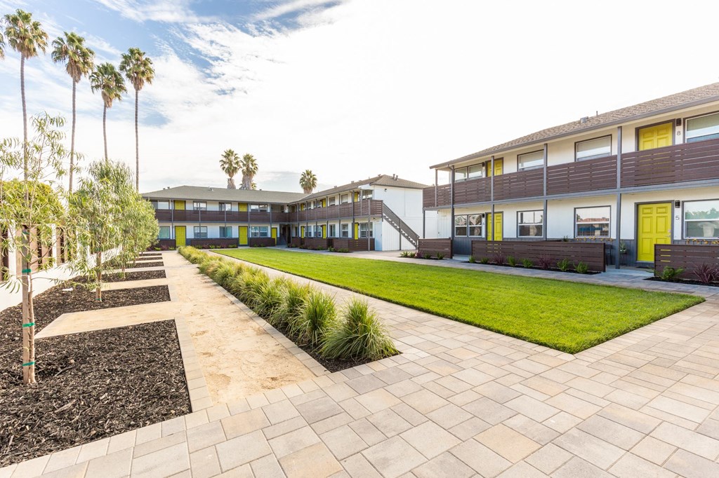 a view of the exterior of a building with a lawn and grass
