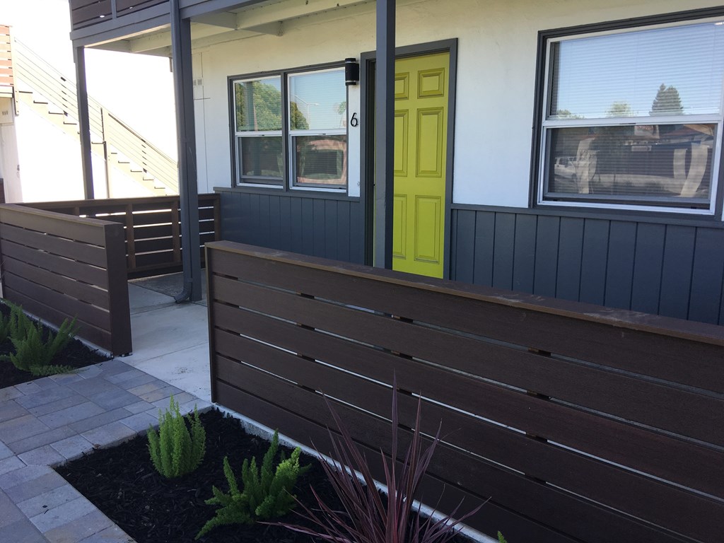 the front porch of a house with a yellow door