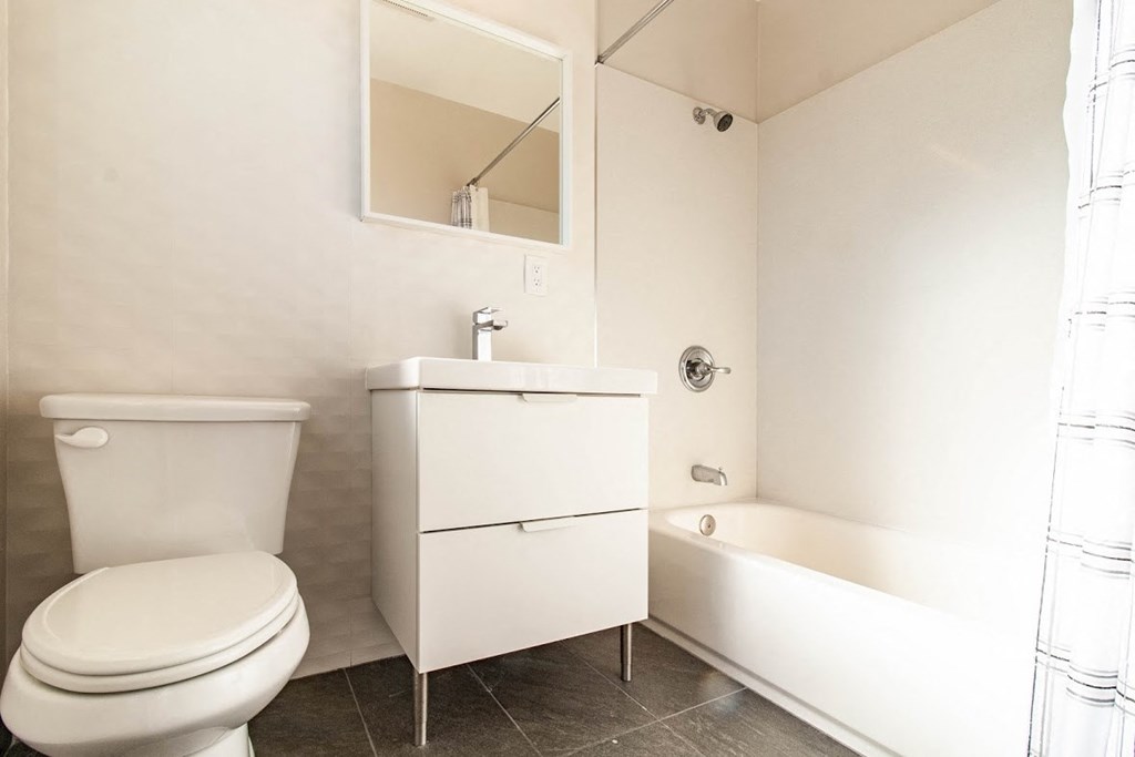 a bathroom with a toilet and a sink and a bath tub