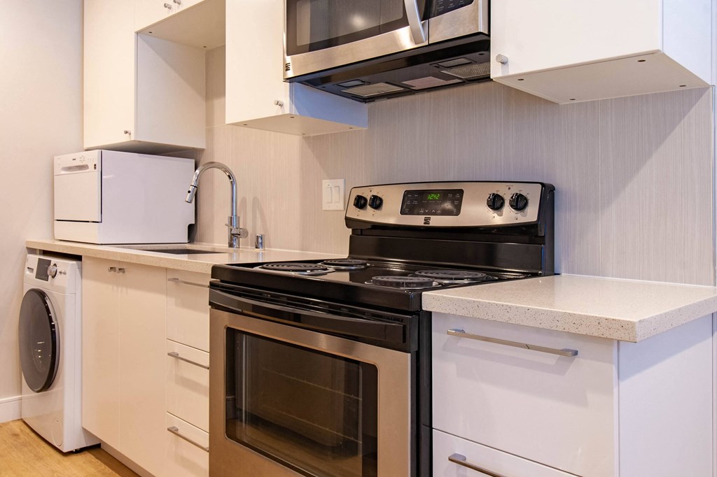 a kitchen with a stove and a sink and a microwave