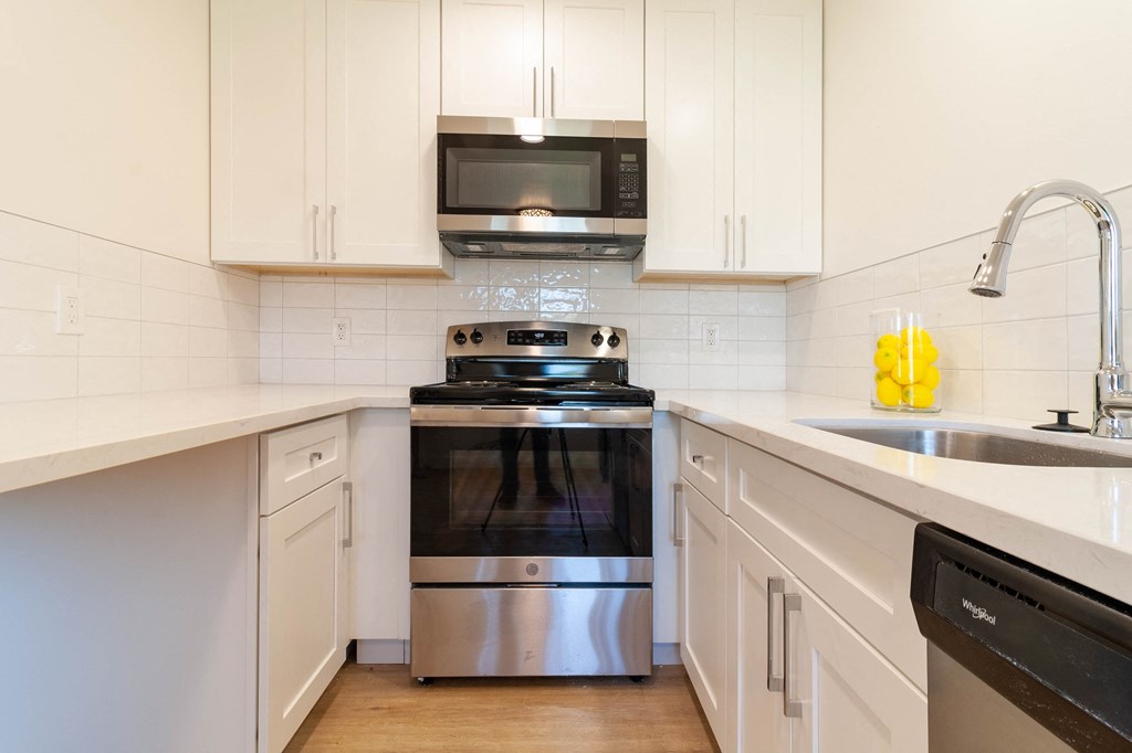 a kitchen with white cabinets and stainless steel appliances