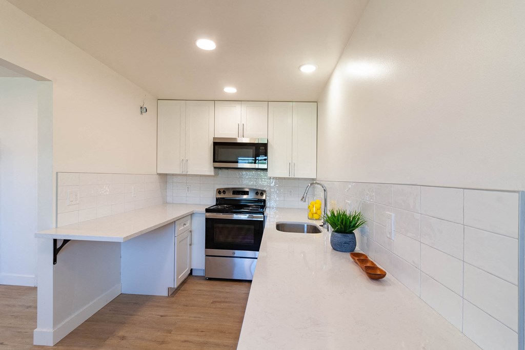 a kitchen with white cabinets and a white counter top