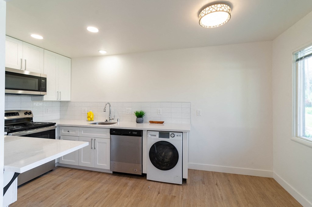 an empty kitchen with a washer and dryer in it