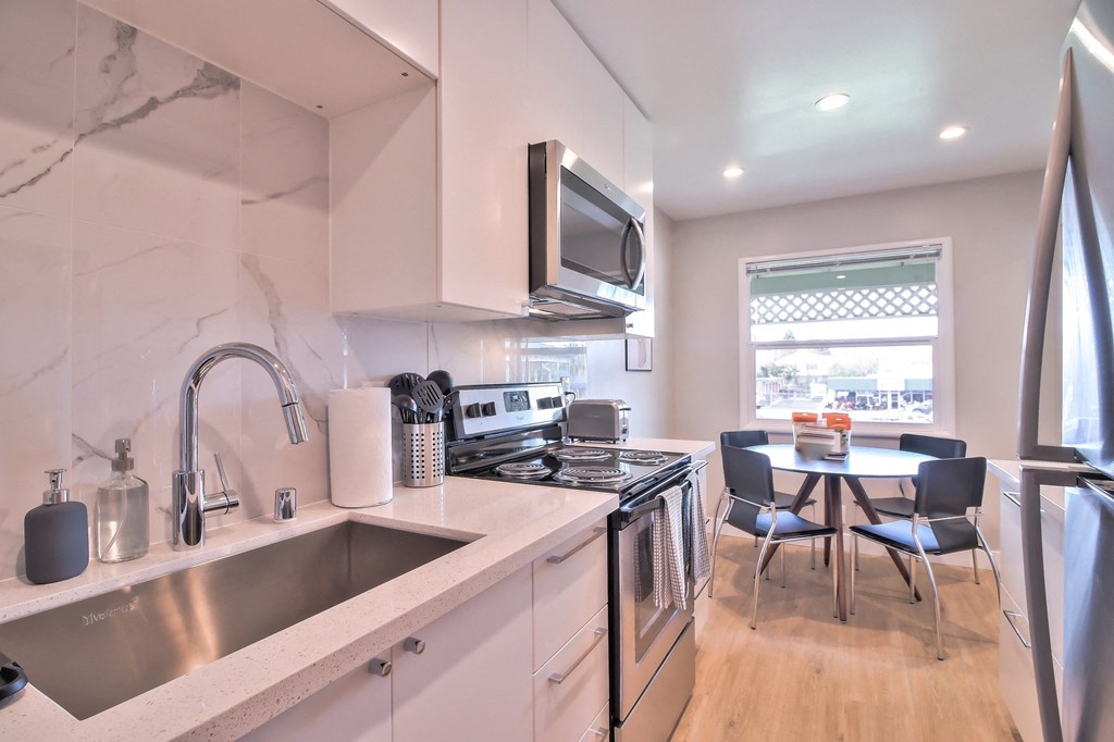 a kitchen with a sink and a table with chairs