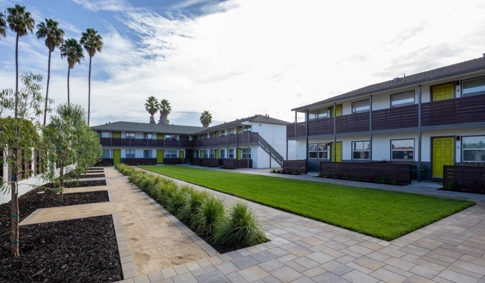 a row of buildings with a lawn and grass