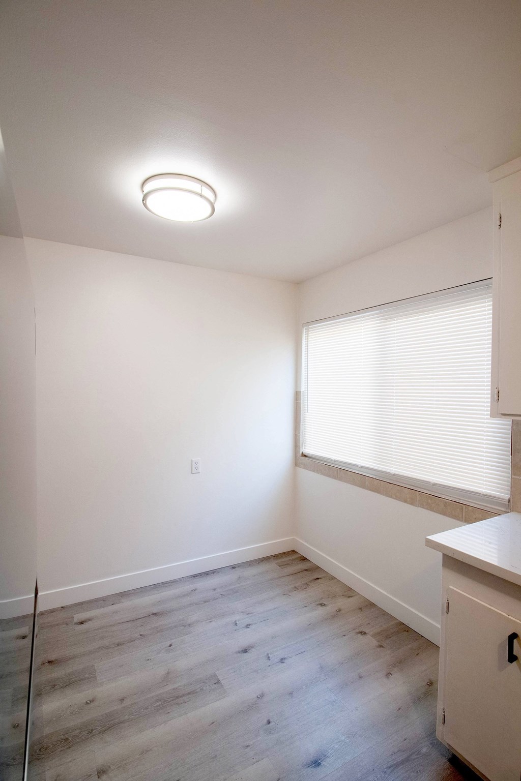 an empty room with wood floors and a window