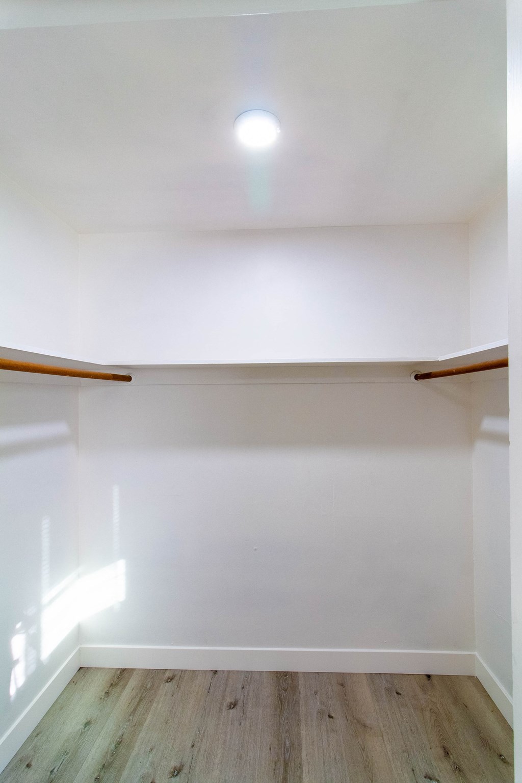 an empty room with white walls and a wood floor