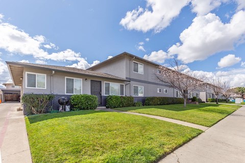 a house with a lawn and a sidewalk in front of it