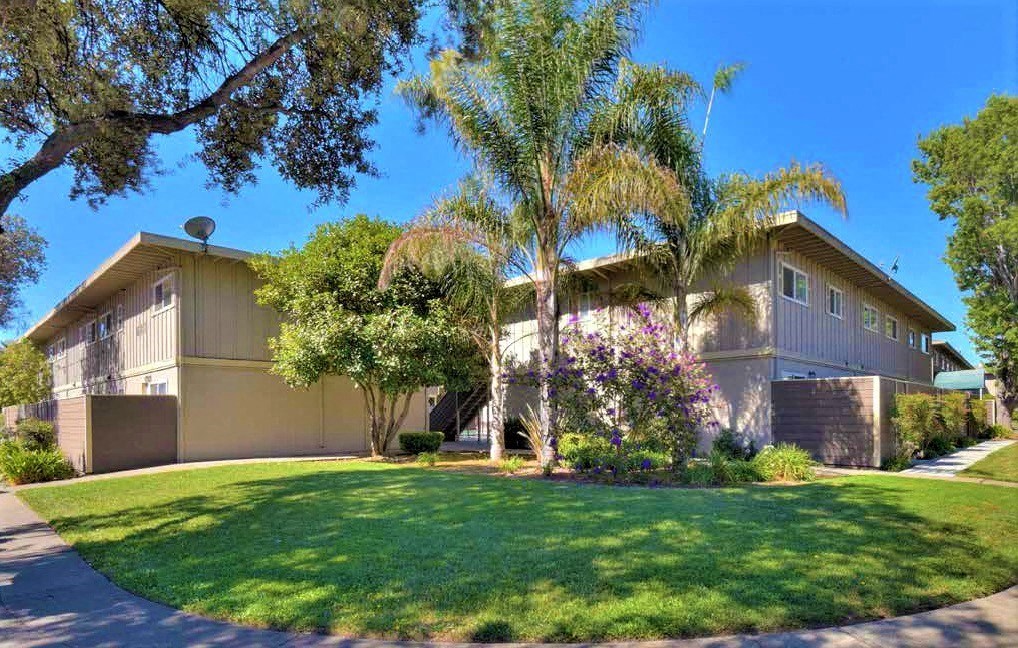 a house with palm trees and grass in front of it