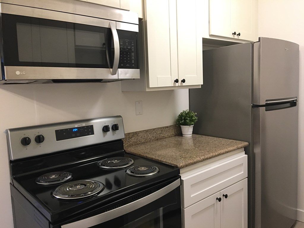 a kitchen with stainless steel appliances and a stove and microwave
