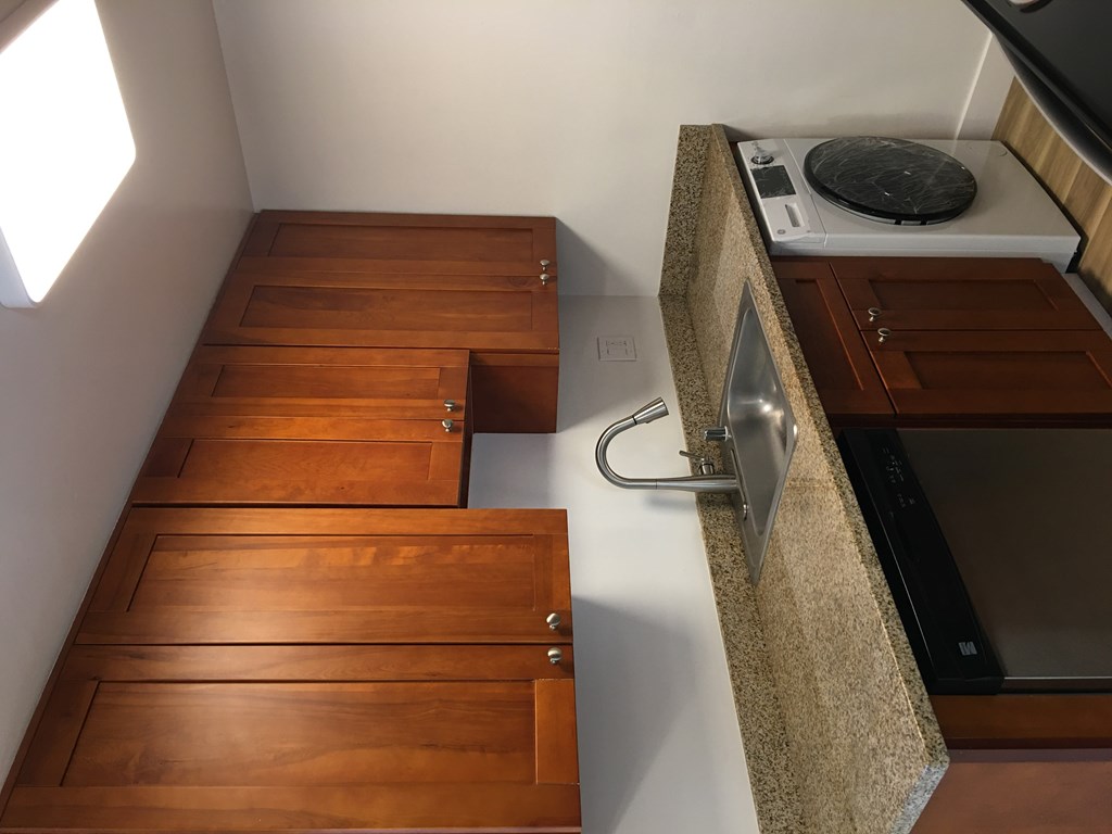 a kitchen with wooden drawers and a stove and a counter