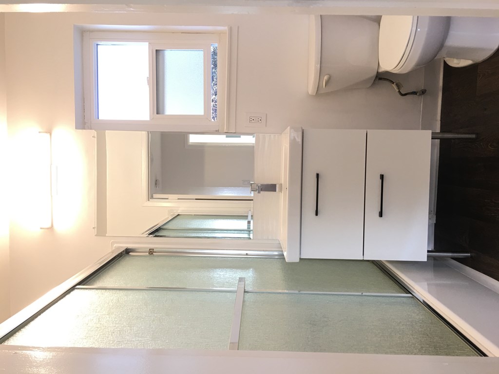a kitchen with white cabinets and a sink and a window