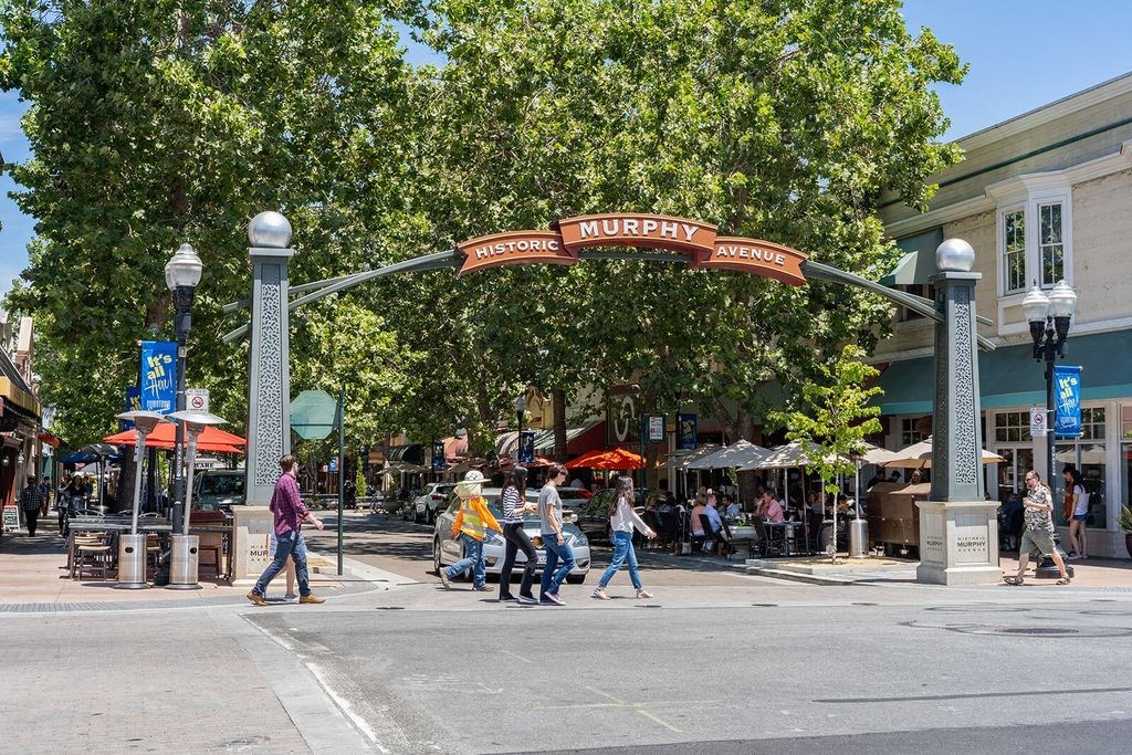 a group of people walking down a street under a sign