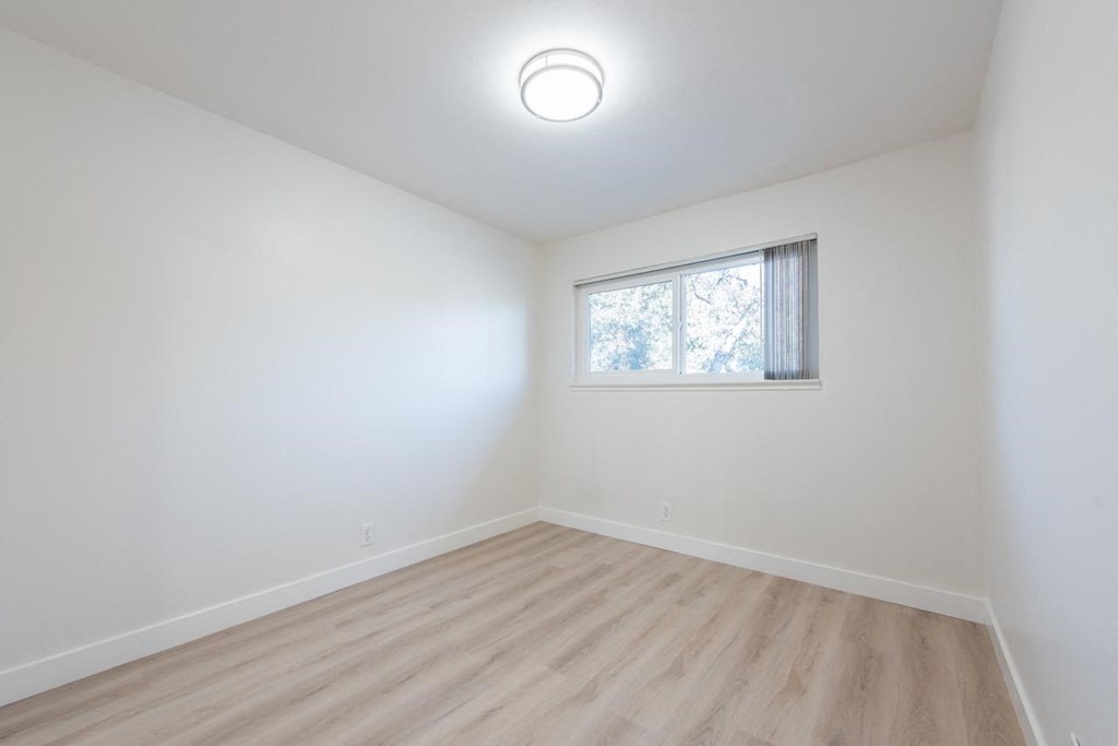 an empty room with white walls and a window