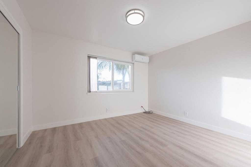 an empty living room with white walls and a window