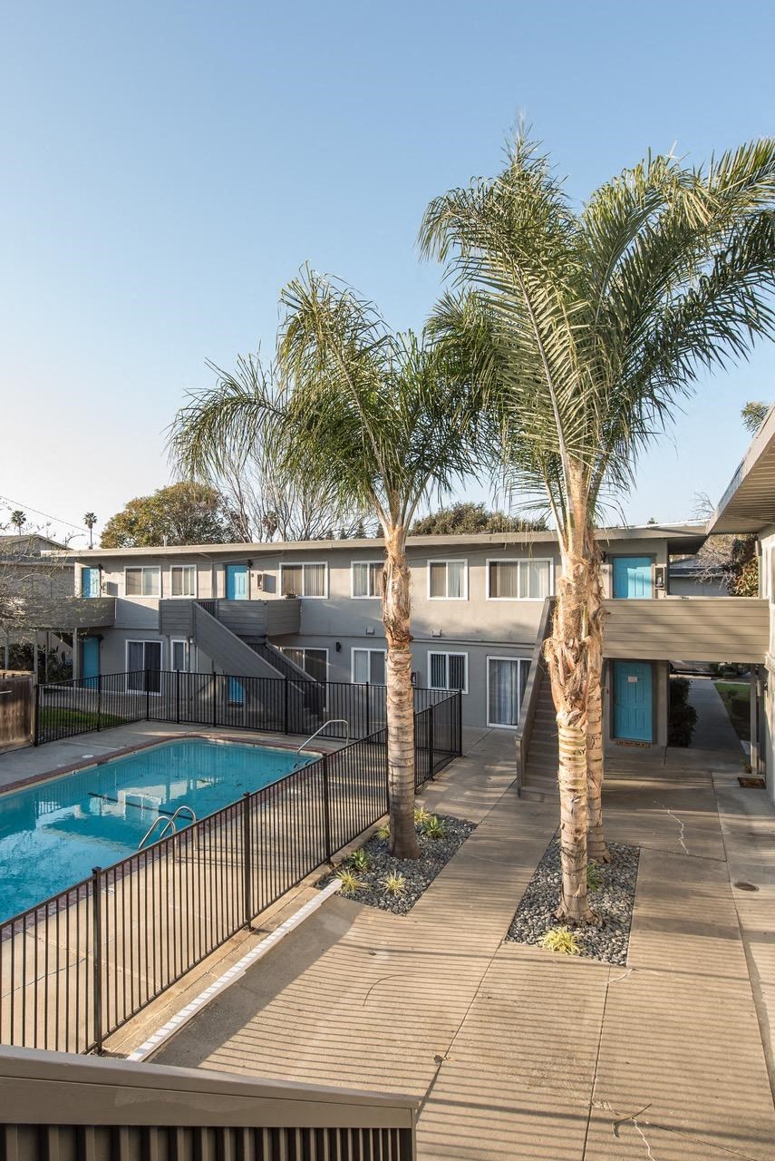 a pool and a building with palm trees