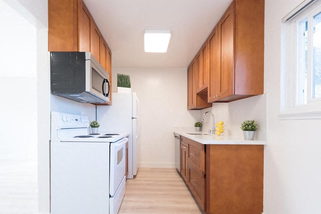 a kitchen with white appliances and wooden cabinets