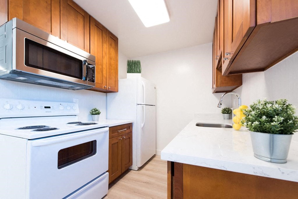 a kitchen with white appliances and wooden cabinets