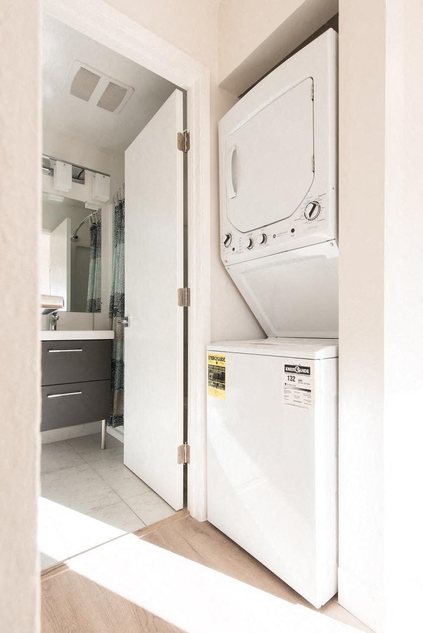 a white washer and dryer in a bathroom next to a door