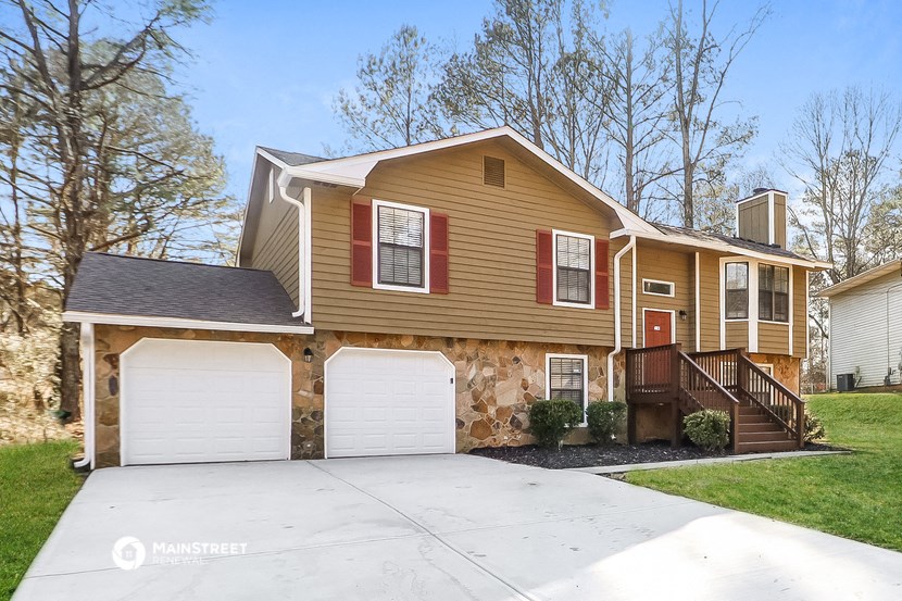 a tan and brown house with two garage doors
