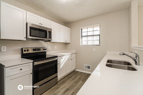 the kitchen of our studio apartment atrium with stainless steel appliances and white cabinets