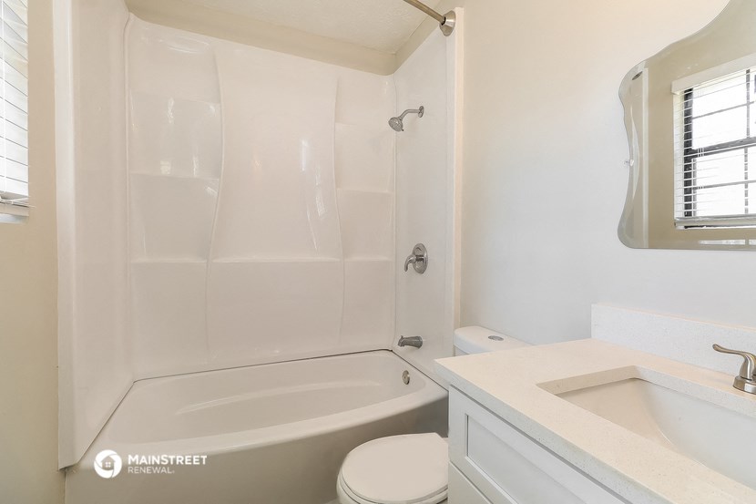 a bathroom with a tub and a sink and a toilet
