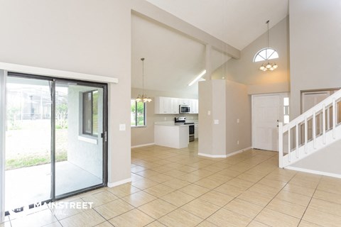 an open kitchen and living room with a sliding glass door