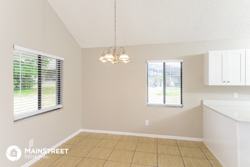 the living room and dining room of a home with a large window