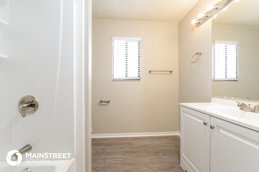 a bathroom with a shower and a sink and a mirror