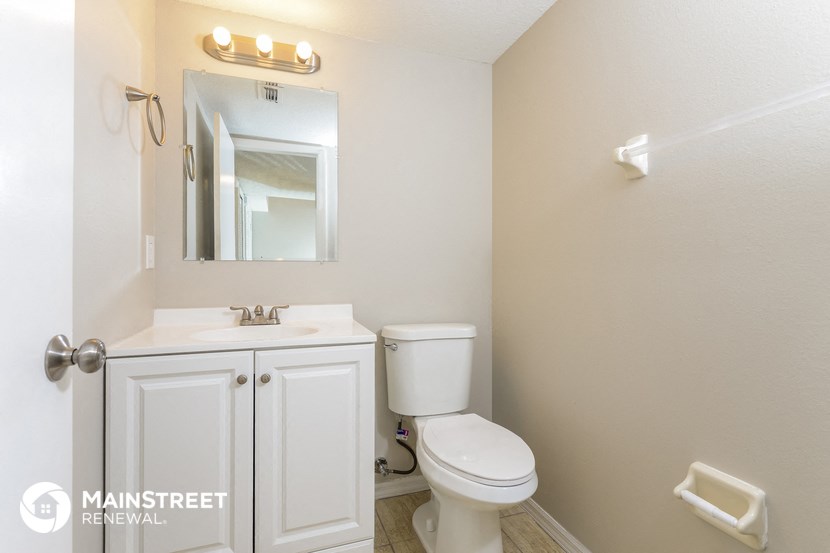 a bathroom with a toilet and a sink and a mirror