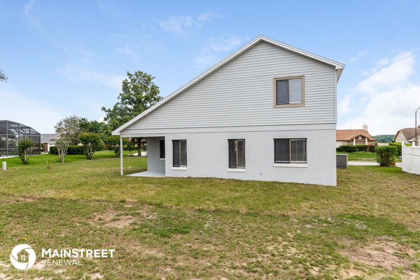 a small white house with a yard and a white house