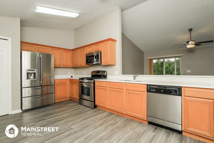 the kitchen has stainless steel appliances and wooden cabinets