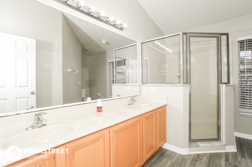 a bathroom with a large mirror and a sink and a shower