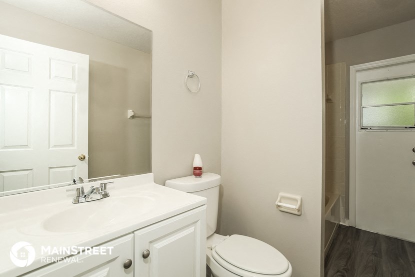 a bathroom with a sink toilet and a mirror