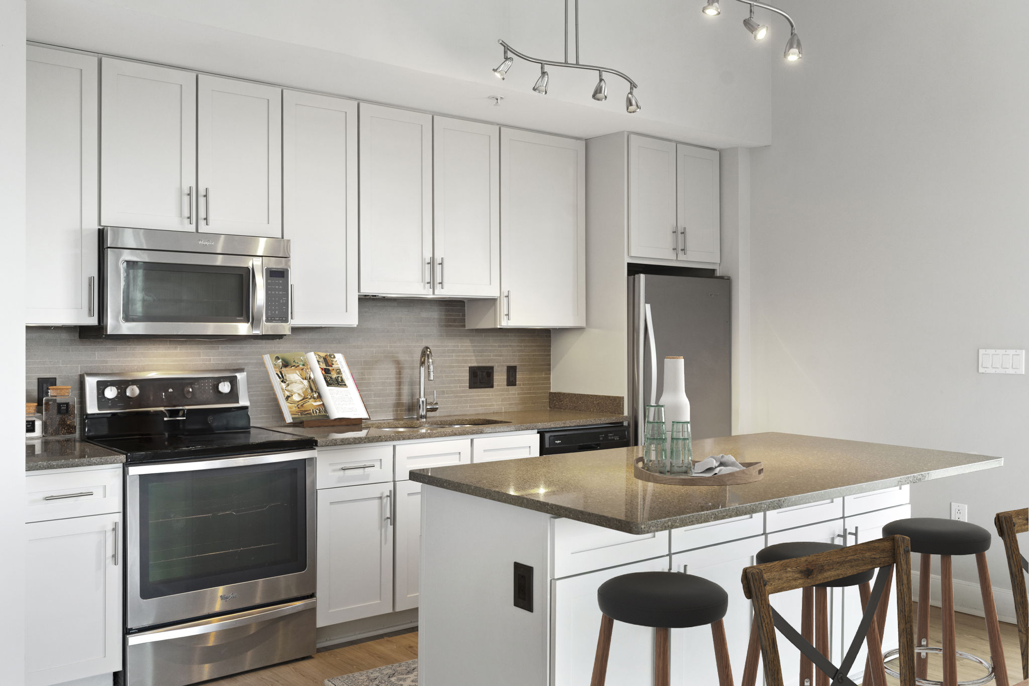 A modern kitchen with white cabinets and stainless steel appliances.