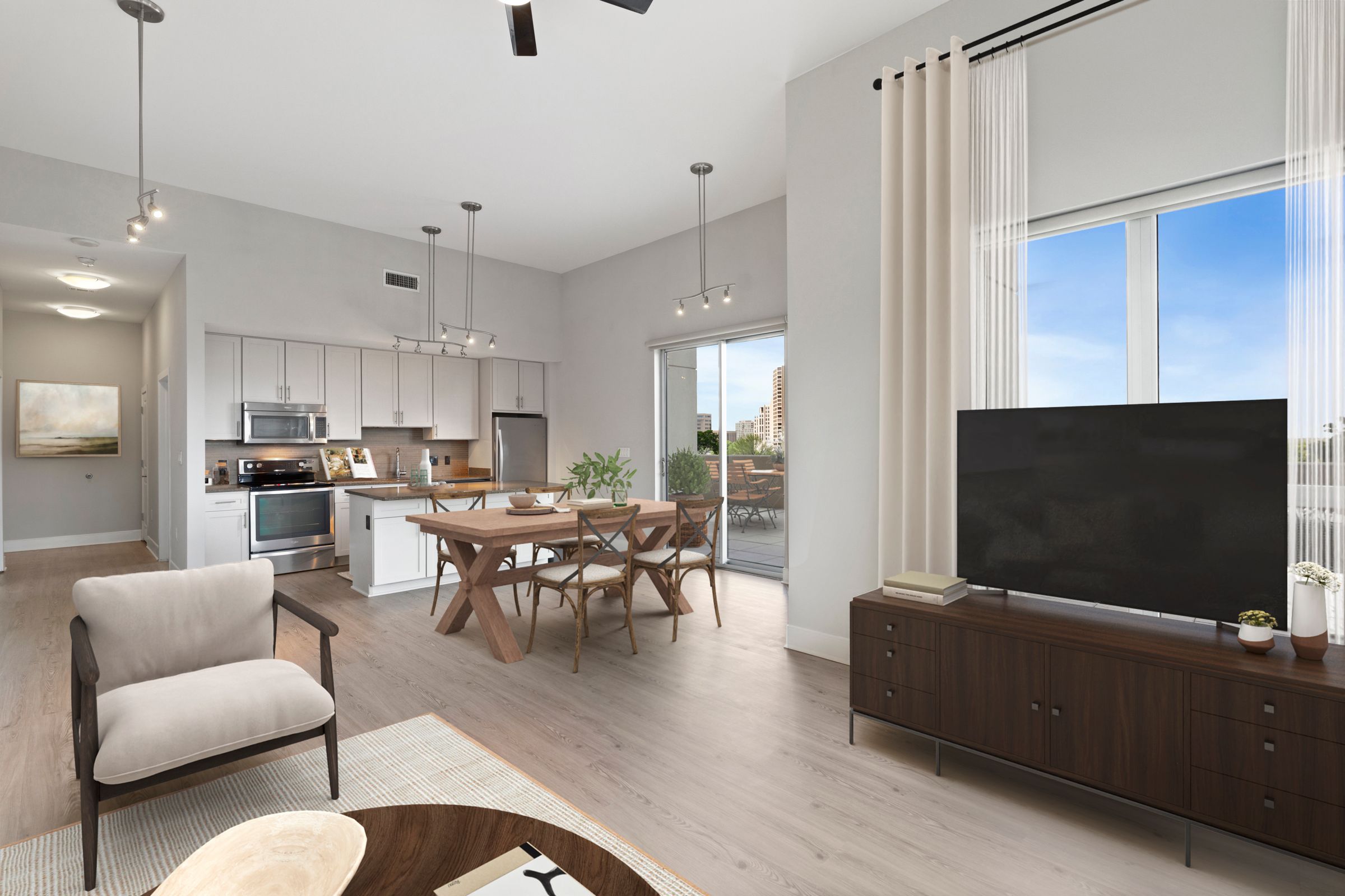A modern living room with a large flat screen TV and a dining table with chairs.