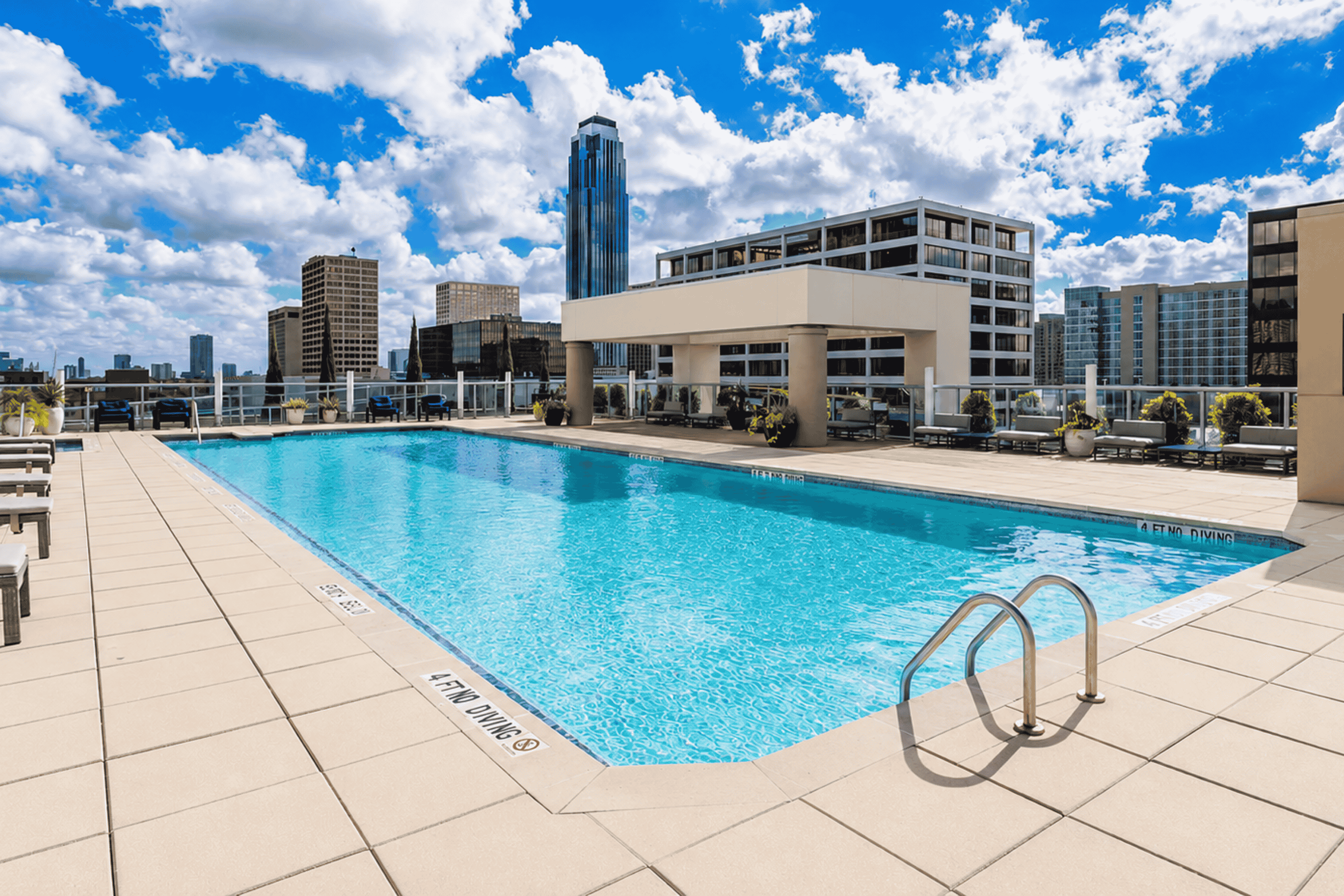 A large swimming pool with a metal ladder in the middle of it.