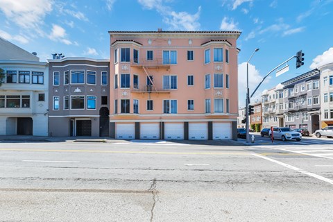 A street view of a building with a parking lot in front.