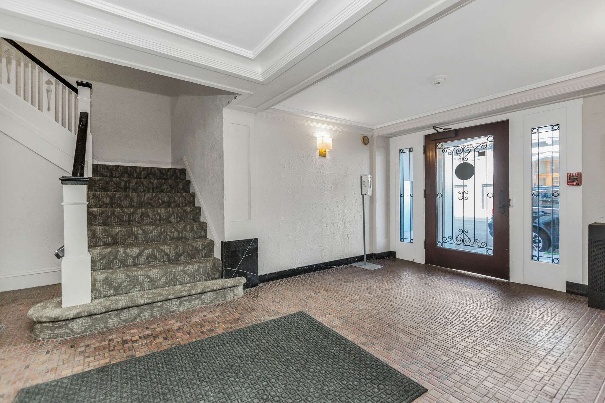 A room with a staircase and a door leading to a balcony.