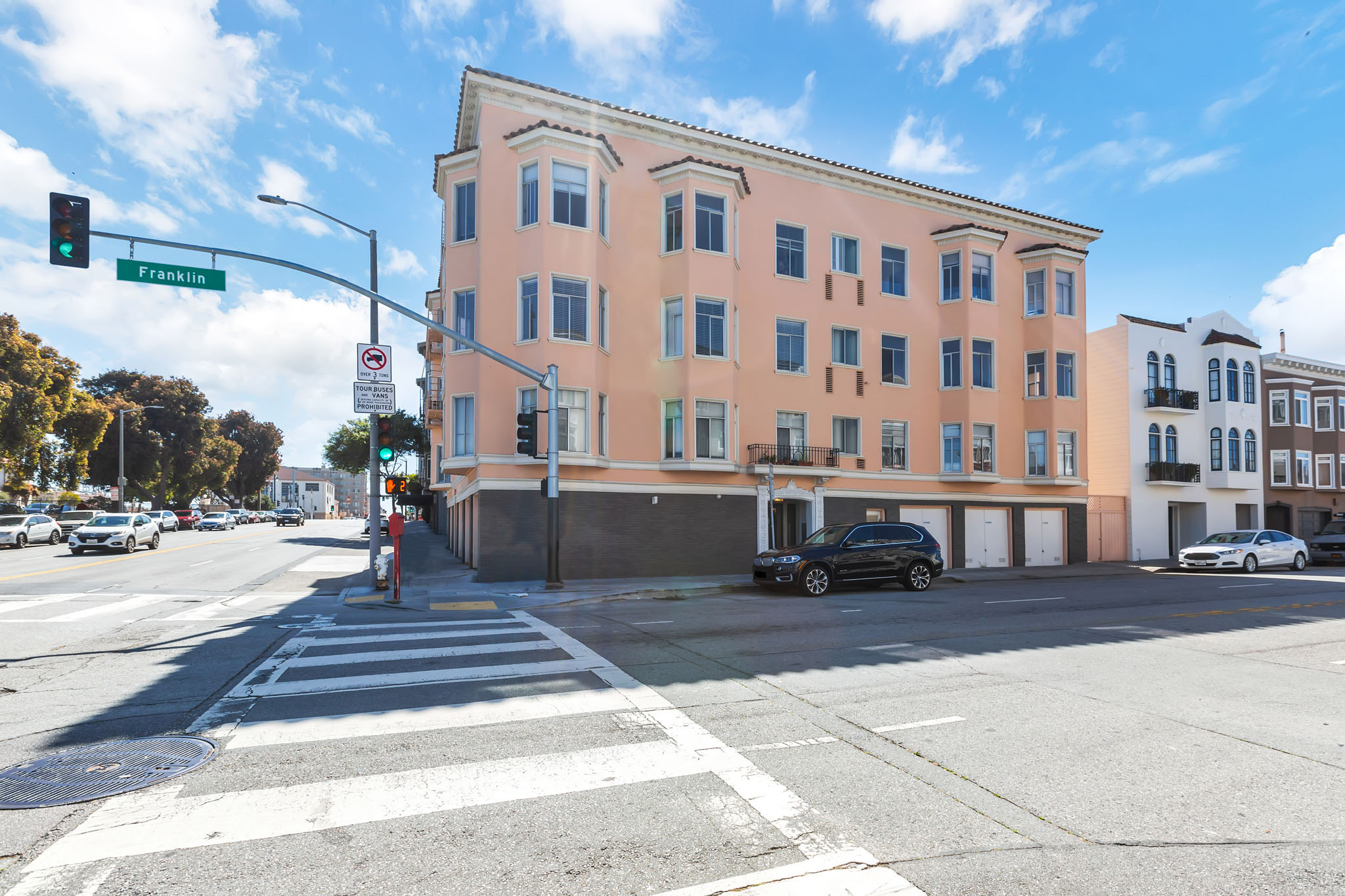 A street view of a crosswalk with a building on the corner.