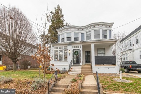 a white house with a porch and stairs