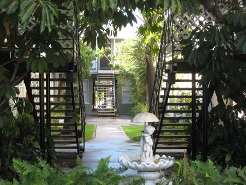 a courtyard with a fountain and a house in the background
