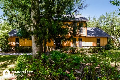 a yellow house with a tree in front of it