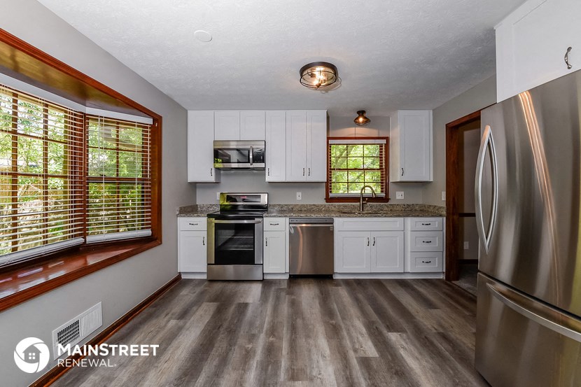a kitchen with white cabinets and stainless steel appliances