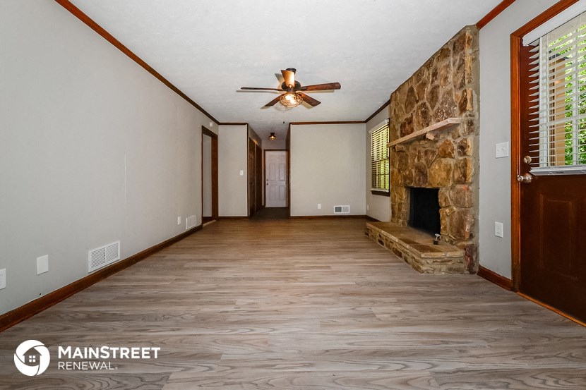a living room with a fireplace and a ceiling fan