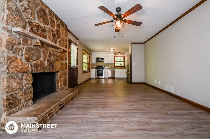 a living room with a stone fireplace and a wooden bench