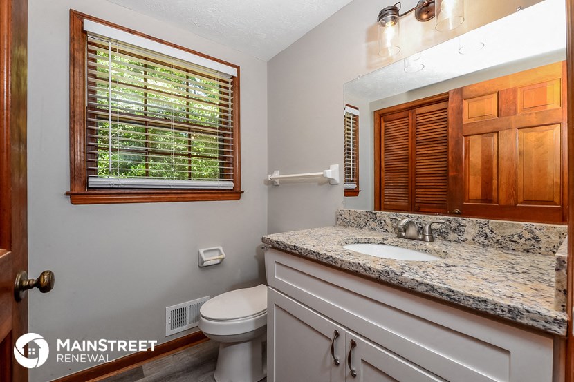 a bathroom with a toilet and a sink and a mirror