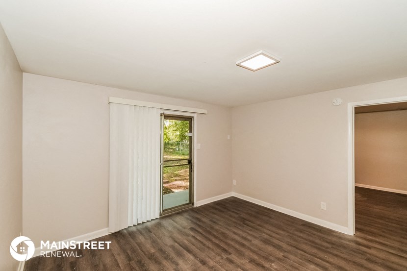 an empty living room with a door to a patio