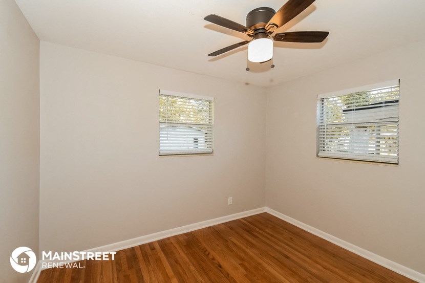 the living room of a home with a ceiling fan and wood floors